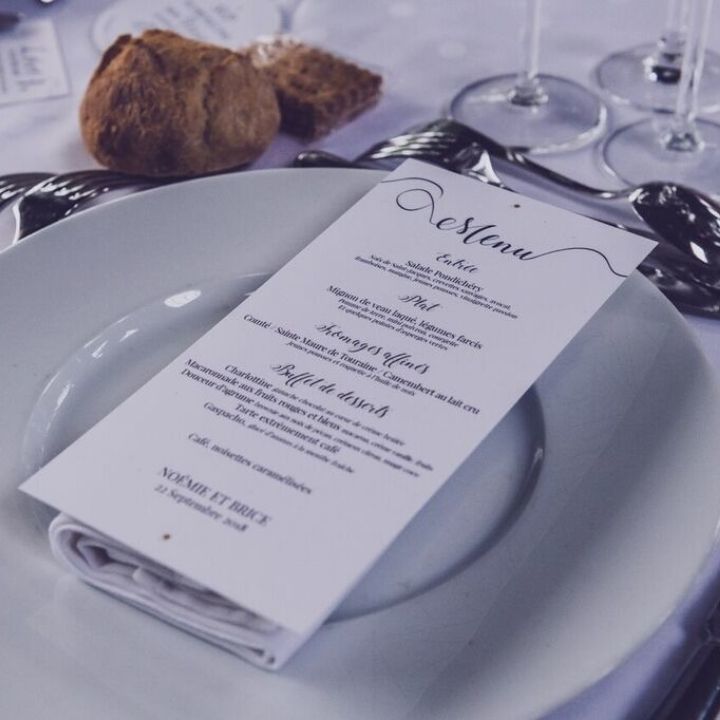 Photo d'une feuille menu posée sur une assiette blanche